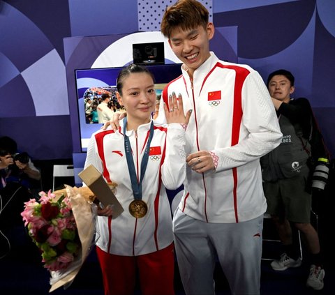 Tak hanya tangis haru dan bahagia, perhelatan Olimpiade Paris 2024 turut diwarnai momen romantis. Sebagaimana yang terlihat di Porte de la Chapelle Arena, pada Jumat (2/8/2024), atlet bulutangkis China Huang Ya Qiong dilamar sang kekasih, Liu Yuchen. Foto: Arun Sankar/AFP