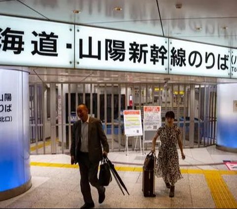 Orang-orang berjalan di depan gerbang tiket ketika layanan kereta cepat Shinkansen ditangguhkan di Stasiun Tokyo, Jepang, pada 31 Agustus 2024. Layanan kereta cepat Shinkansen antara Tokyo dan Nagoya lumpuh setelah Jepang dilanda terjangan Topan Shanshan. Foto: Philip Fong/AFP