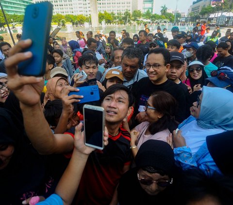 Gubernur DKI Jakarta periode 2017-2022, Anies Baswedan mengunjungi kawasan Car Free Day (CFD) di Bundaran HI, Jakarta, pada Minggu (4/8/2024). Kedatangan Anies langsung menarik perhatian para pengunjung CFD. Foto: Merdeka.com/Arie Basuki