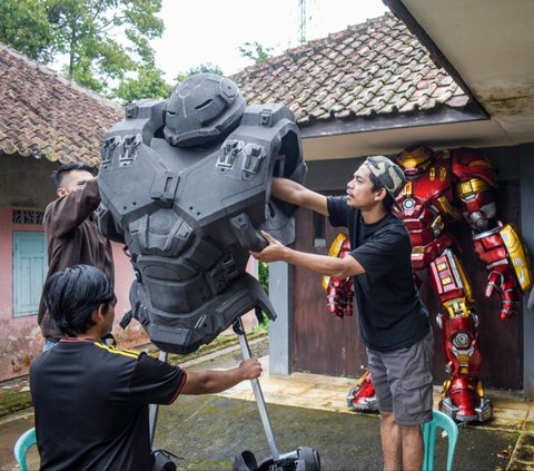 Sejumlah perajin menyelesaikan pembuatan kostum robot Hulkbuster di rumah produksi Cosmake Heroic di Kabupaten Ciamis, Jawa Barat, Sabtu (3/8/2024). Kostum robot yang dibuat menggunakan bahan EVA foam ini ternyata menarik minat pasar internasional. Foto: Timur Matahari/AFP