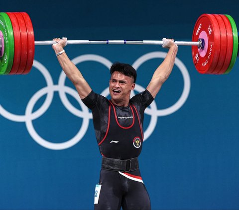 Aksi atlet angkat besi Indonesia, Rizki Juniansyah melakukan angkatan clean and jerk seberat 199 kg saat berdanding dalam nomor 73 kg putra Olimpiade 2024 Paris, Jumat (9/8/2024) dini hari WIB. Berkat perjuangan kerasnya, Rizki berhasil meraih medali emas Olimpiade 2024 dari angkat besi 73 kg putra. Foto: REUTERS/Amanda Perobelli