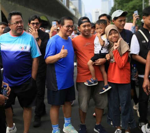 FOTO: Kompak Pakai Kaos dan Celana Pendek, Pasangan Pramono Anung-Rano Karno Olahraga Jalan Santai di CFD Jakarta