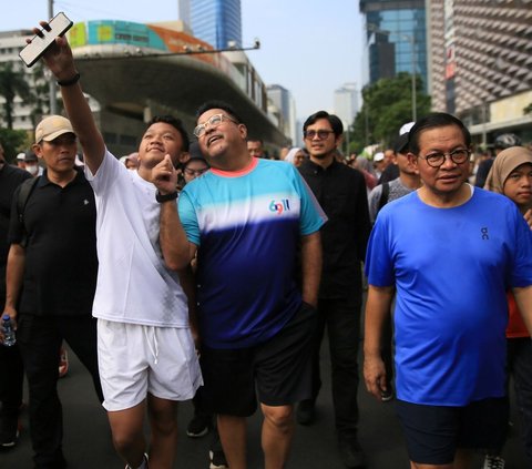 FOTO: Kompak Pakai Kaos dan Celana Pendek, Pasangan Pramono Anung-Rano Karno Olahraga Jalan Santai di CFD Jakarta