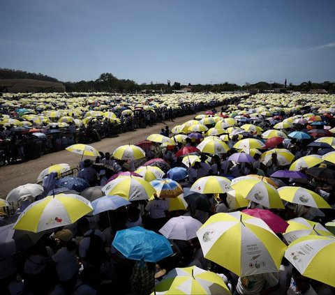 Di bawah terik matahari, para umat Katolik tampak menantikan momen bersejarah ini, di mana pemimpin Gereja Katolik dunia akan memimpin misa akbar di negara yang mayoritas penduduknya beragama Katolik. Foto: Reuters