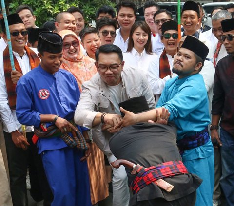 Calon Gubernur DKI Jakarta Ridwan Kamil  disambut tradisi palang pintu saat menyambangi kantor Tim Kampanye Nasional Pemilih Muda (TKN-Fanta), Menteng, Jakarta Pusat, Senin (02/09/2024).