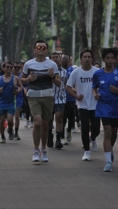 Peserta maraton TMII Running Club berlari melewati lintasan pada Taman Mini Indonesia Indah (TMII), Jakarta, Jumat (20/9/2024). Foto: Merdeka.com/Imam Buhori