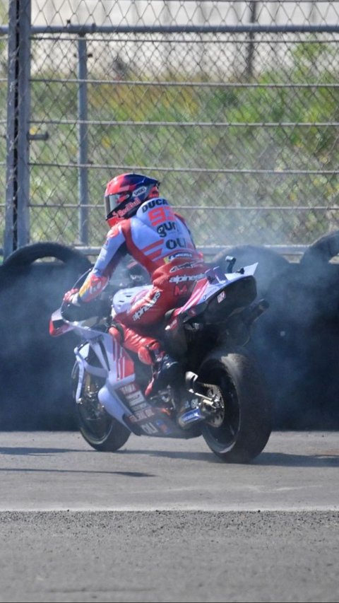 Api yang muncul dengan cepat itu langsung menjalar, dan Marquez yang terlihat kesal langsung menepikan motornya. Foto: BAY ISMOYO / AFP