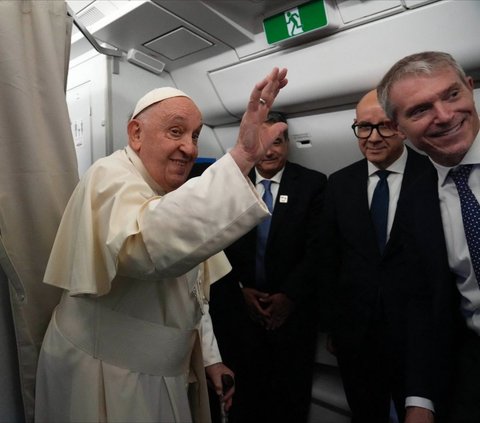 Pemimpin Gereja Katolik Dunia, Paus Fransiskus melambaikan tangannya kepada para penumpang pesawat saat melakukan perjalanan menuju Indonesia dari Bandara Fiumicino, Roma, Italia, Senin (2/9/2024). Bukan jet pribadi, Paus Fransiskus menempuh perjalanan beribu-ribu kilometer menuju Indonesia menggunakan pesawat komersil biasa. Foto: AFP/Pool/Gregorio Borgia