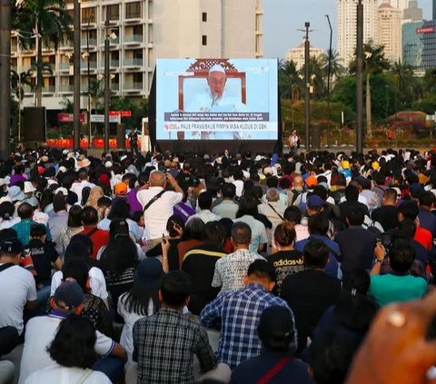 FOTO: Tak Bisa Masuk GBK, Umat Katolik Tetap Khidmat Ikuti Misa Suci Paus Fransiskus Meski Lewat Layar Lebar