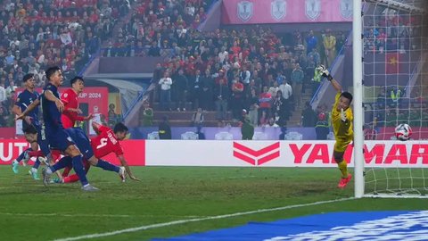 Pemain naturalisasi baru Vietnam, Nguyen Xuan Son (kiri) menggiring bola melewati pemain Thailand, Nicholas Mickelson dalam laga leg pertama final Piala AFF 2024 yang berlangsung di Viet T