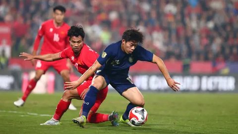 Pemain naturalisasi baru Vietnam, Nguyen Xuan Son (kiri) menggiring bola melewati pemain Thailand, Nicholas Mickelson dalam laga leg pertama final Piala AFF 2024 yang berlangsung di Viet T