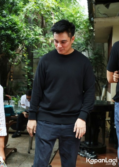 Baim Wong keluar rumah untuk menyapa para pelayat yang datang ke kediamannya untuk menyampaikan bela sungkawa. Ia mengenakan baju serba hitam dan tampak lesu.