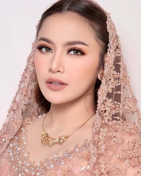 Makeup Mahalini yang cantik dengan tema warna peach yang kalem dan indah. Beri kesan adem dengan selendang brokat yang senada.&nbsp;