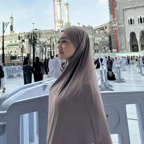 Memakai pakaian tertutup selama beribadah, Naura Ayu tampil beda dari biasanya yang tampak dewasa dan seksi.&nbsp;