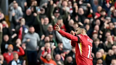 Pemain Liverpool, Mohamed Salah tampak diadang pemain MU Diogo Dalot. (Darren Staples / AFP)