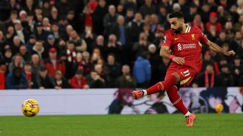 Pemain Liverpool, Mohamed Salah tampak diadang pemain MU Diogo Dalot. (Darren Staples / AFP)