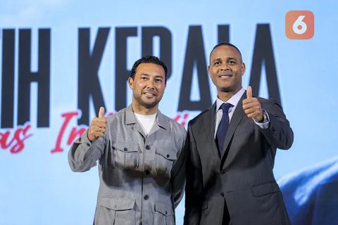 Pelatih kepala baru Timnas Indonesia, Patrick Kluivert berpose dengan memegang jersey dan memakai peci setelah sesi konferensi pers yang berlangsung di Hotel Mulia, Senayan, Jakarta, Mingg