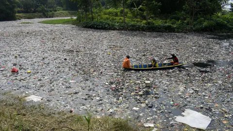 Bersama sejumlah relawan dan alat berat, petugas Balai Besar Wilayah Sungai (BBWS) Citarum berupaya membersihkan tumpukan sampah yang didominasi pencemaran domestik atau limbah rumah tangga. (Timur MATAHARI/AFP)