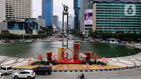 Sejumlah pengendara kendaran bermotor melintasi dekorasi ornamen khas perayaan Imlek di Bundaran Hotel Indonesia, Jakarta, Senin (27/1/2025). (Liputan6.com/Angga Yuniar)