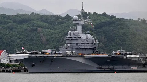 Foto memperlihatkan kapal induk bertenaga nuklir milik Angkatan Laut Prancis, Charles de Gaulle yang berlabuh di pelabuhan Gili Mas, Lembar, Lombok pada 31 Januari 2025. (SONNY TUMBELAKA/AFP)