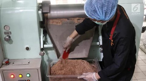 Pekerja mengeluarkan cokelat dari cetakan di toko Pipiltin Cocoa kawasan Barito, Jakarta, Kamis (13/9). Pipiltin Cocoa memiliki beragam rasa, varian, dan ukuran. (Liputan6.com/Herman Zakharia