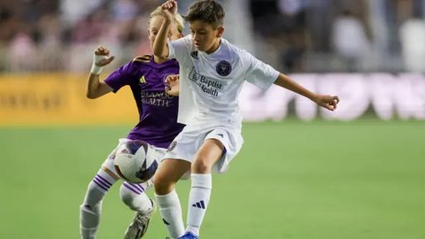 Pemain depan Inter Miami asal Argentina, Lionel Messi (tengah-kiri), dan putranya, pemain U-12 Inter Miami, Thiago Messi (tengah-kanan), tiba di lapangan untuk pertandingan perdana Inter M