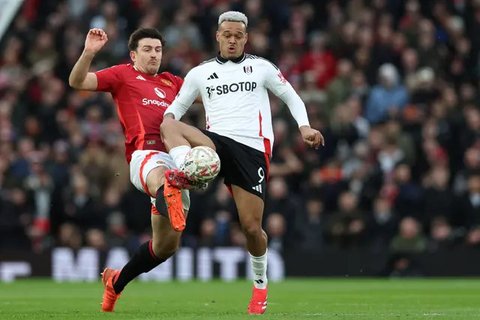 Bek Manchester United asal Inggris Harry Maguire (kiri) beradu penalti dengan penyerang Fulham asal Brasil Rodrigo Muniz (kanan) selama pertandingan sepak bola putaran kelima Piala FA
