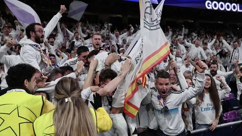Penyerang Real Madrid, Brahim Diaz melompat ke tribun penonton setelah mencetak gol kedua bagi timnya pada pertandingan leg pertama 16 besar Liga Champions 2024/2025 melawan Atletico de Madrid di stadion Santiago Bernabeu, Madrid, pada 4 Maret 2025 waktu setempat atau Rabu (5/3/2025) dini hari WIB. (Thomas COEX/AFP)