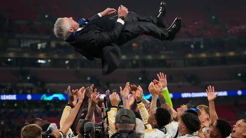 Carlo Ancelotti dan para pemain Real Madrid mengangkat trofi Liga Champions 2023/2024, Minggu (2/6/2024) dini hari WIB. (GLYN KIRK / AFP)