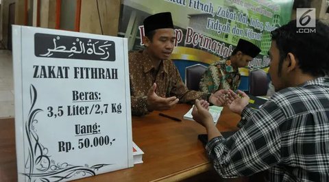 Petugas amil zakat melayani warga yang membayar zakat fitrah di Masjid Istiqlal, Jakarta, Selasa (18/4/2023). (Liputan6.com/Herman Zakharia)