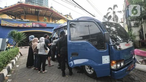 Warga menukarkan uang pecahan kecil di mobil Kas Keliling BI, Pasar Rawa Bening, Jakarta Timur, Senin (18/4/2022). Untuk mencegah virus corona, BI meminta masyarakat mendaftar melalui aplikas