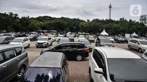 Mobil pengunjung melintasi pintu parkir IRTI Monas, Jakarta, Rabu (15/2/2023). Mobil yang telah lolos uji emisi akan dikenakan tarif parkir sebesar Rp 4.000 per jam, sedangkan yang belum lolo