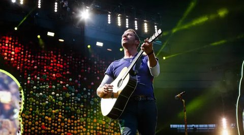 Penampilan vokalis Coldplay, Chris Martin saat tampil di The Stade de France Arena di Saint Denis, Paris, Prancis (15/7). (AFP Photo/Geoffroy Van Der Hasselt)