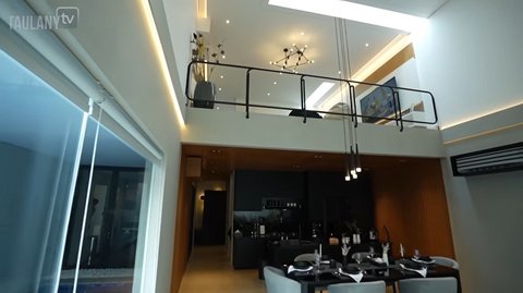 Area dapur dan ruang makan tersembunyi di bawah Mezzanine. Ini menunjukkan dapur yang berada tepat di bawah area mezzanine. Ruang ini tampak rapi dan harmonis berkat penataan pencahayaan serta elemen kayu yang membungkus langit-langit.