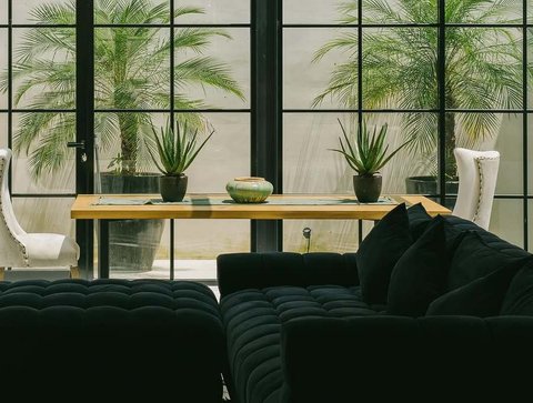 Perpaduan warna hijau gelap dan putih mendominasi interior, menciptakan suasana yang berkelas dan menawan, lengkap dengan jendela kaca yang besar.