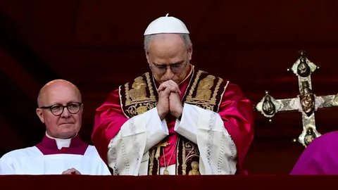 Paus Leo XIV yang baru terpilih, Robert Francis Prevost melambaikan tangan dari balkon loggia pusat utama Basilika Santo Petrus untuk pertama kalinya, setelah para kardinal mengakhiri konklaf
