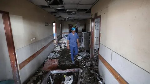 Salah satu staf rumah sakit Palestina memeriksa kerusakan di dalam rumah sakit Nasser di Khan Yunis, Jalur Gaza selatan, menyusul serangan Israel pada 13 Mei 2025. (Eyad BABA/AFP)