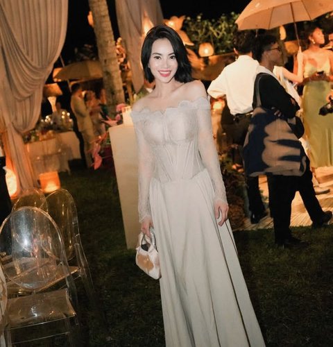 Di pernikahan Luna Maya,&nbsp;Dearly Djoshua tampil memukau dalam gaun off-shoulder nude dengan detail corset lace yang mempertegas siluet tubuhnya. Lengan panjang transparan memberi sentuhan mewah dan feminin. Riasan flawless bernuansa soft glam melengkapi penampilannya, memancarkan aura classy.