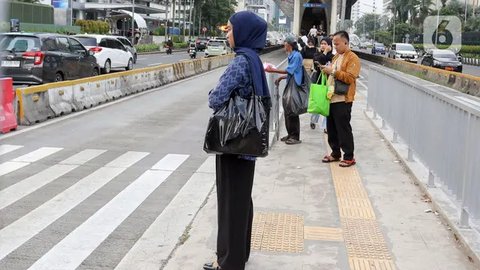 Sejumlah pekerja mengenakan masker melintas saat jam pulang kerja di kawasan Sudirman, Jakarta, Rabu (16/8/2023). (Liputan6.com/Angga Yuniar)