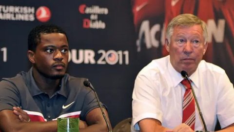 Mantan manajer Manchester United, Sir Alex Ferguson, duduk di kotak direktur bersama mantan pemain United, bek Prancis, Patrice Evra, selama pertandingan Liga Primer Inggris antara Manches