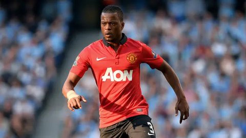 Mantan manajer Manchester United, Sir Alex Ferguson, duduk di kotak direktur bersama mantan pemain United, bek Prancis, Patrice Evra, selama pertandingan Liga Primer Inggris antara Manches