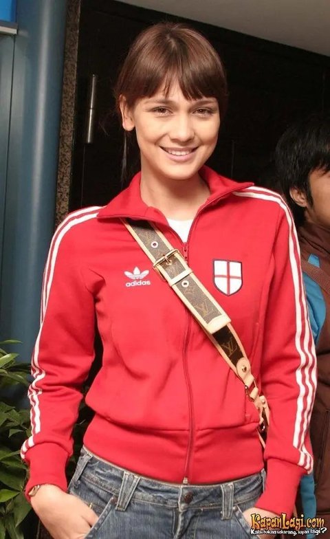 Mengenakan jaket training merah, Luna Maya saat itu masih terlihat muda. Ia pun tampil natural dengan memerlihatkan wajah blasteran yang memesona. Dengan rambut pirang diikat ke belakang lengkap dengan poni depannya. [Dok. Kapanlagi.com]