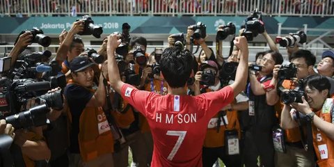 Penyerang Korea Selatan, Son Heung-min, menggigit mendali, usai menjuarai Asian Games dengan mengalahkan Jepang di Stadion Pakansari, Jawa Barat, Sabtu (1/9/2018). (AP/Bernat Armangue)