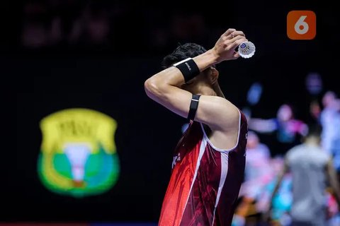 Pebulu tangkis tunggal putra Indonesia, Jonatan Christie menyeka keringatnya dalam laga 32 besar Indonesia Open 2025 saat melawan wakil Singapura, Jia Heng Jason Teh di Istora Senayan, Jakarta, Selasa (03/06/2025). (Bola.com/Bagaskara Lazuardi)