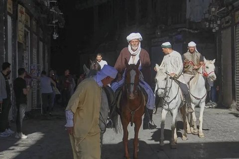 Jemaah haji, termasuk tiga orang dari Spanyol, berpose dengan kuda mereka di luar Pasar al-Hamidiyah di Damaskus, Suriah, 21 April 2025, selama perjalanan berkuda selama berbulan-bula