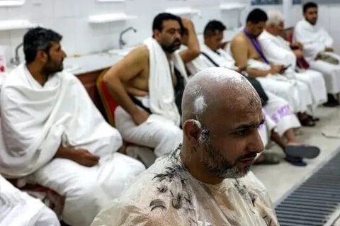Jemaah haji 2025 menunggu di luar tempat pangkas rambut untuk dipotong rambut di Mina pada 6 Juni 2025. (HAZEM BADER/AFP)