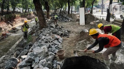 Pekerja menyelesaikan proyek perbaikan turap pada pecahan aliran Kali Ciliwung di kawasan Minangkabau, Jakarta, Rabu (11/6/2025). (Liputan6.com/Herman Zakharia)