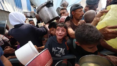 Salah satu anak Palestina menangis saat menunggu pembagian makanan di sebuah titik distribusi di Nuseirat, Jalur Gaza Tengah, pada 11 Juni 2025. (Eyad BABA/AFP)