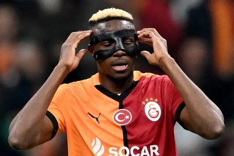 Penyerang Galatasary asal Nigeria, Victor Osimhen, menyesuaikan topengnya setelah mencetak gol pada Liga Europa, fase Liga - Matchday 4, melawan Tottenham di Ali Sami Yen Spor Complex di