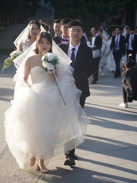 Beberapa pasangan pengantin bersiap untuk berfoto di Nanjing, Provinsi Jiangsu, China timur, (19/5/2020). Sebanyak 15 pasangan pengantin pada Selasa (19/5) berfoto bersama di Nanjing